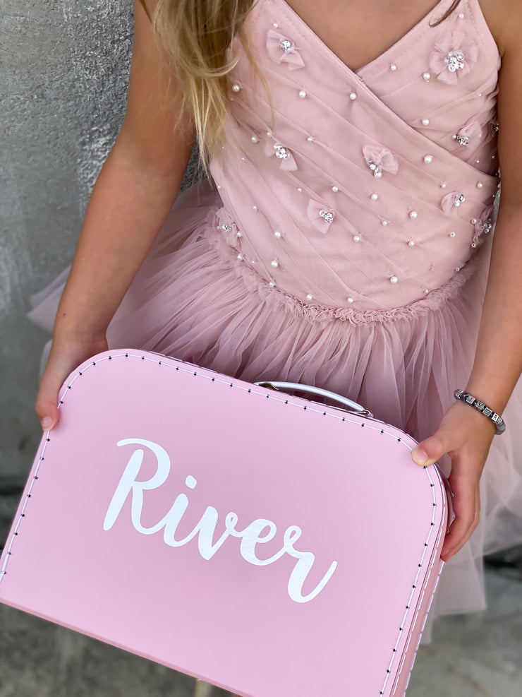 girl wearing pink tulle dress, holding a size large pink box